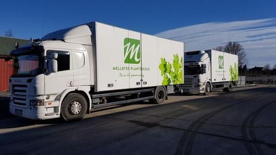 To store, hvite lastebiler med logo for Mellbyes planteskole